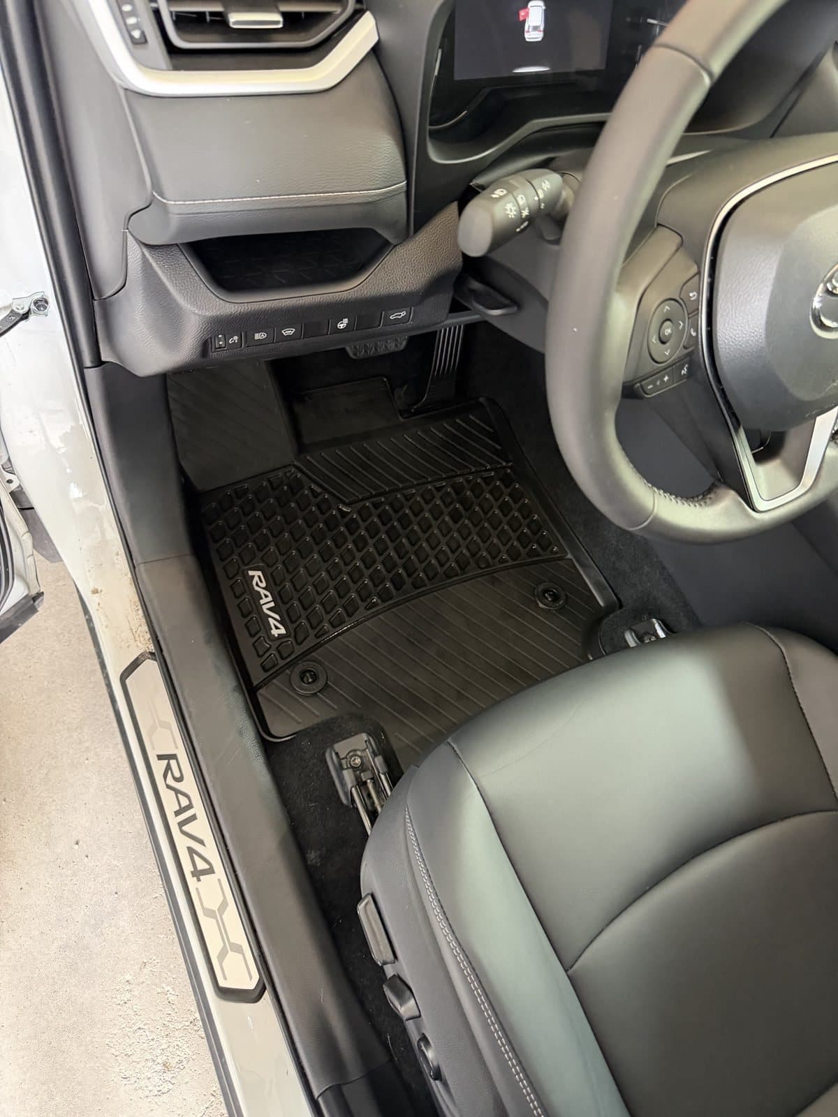 The same RAV4 footwell after detailing, mat and sill cleaned back to factory black